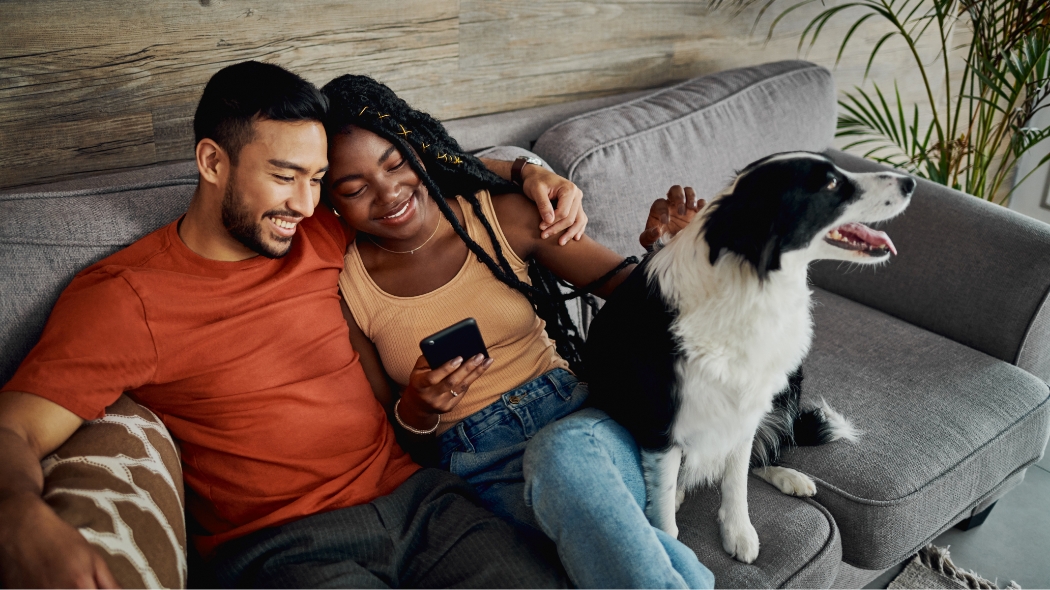 A man on his mobile phone with his Labrador retriever in his lap.
